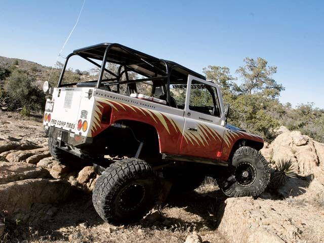 05094wd_06z+1995_Land_Rover_Defender_90+Rear_Passengers_Side_View_On_Rocks.jpg