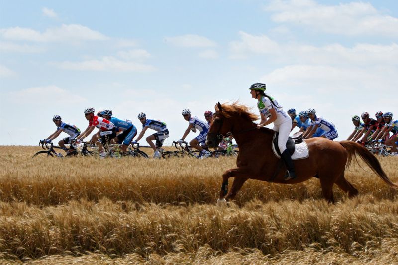 TF 0028 A woman on a horse runs alongside the peloton during stage five of the 2008 Tour de France f